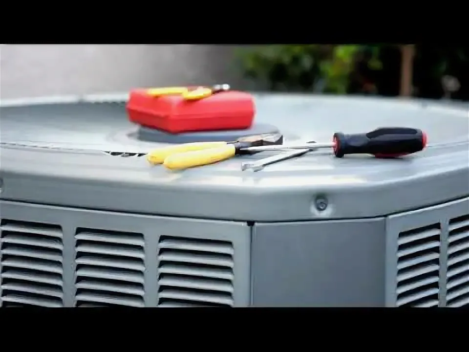 HVAC Running Constantly But Not Cooling while a red tool case, yellow-handled pliers, and a black-handled screwdriver rest on top of a gray metal outdoor air conditioning condenser unit during maintenance inspection.
